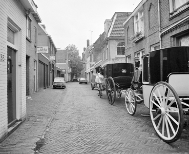 857982 Gezicht in de Keukenstraat te Utrecht, met twee koetsjes van stalhouderij Schoonhoven-Buytendijk (Nieuwegracht 68).